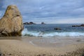 Sea waves crashing over rocks on a sandy beach Royalty Free Stock Photo