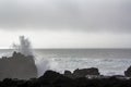 Waves crashing against black volcanic rock formations Royalty Free Stock Photo