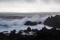 Waves crashing against black volcanic rock formations Royalty Free Stock Photo