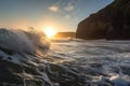 waves crashing against the cliff face, with sun peeking over the horizon Royalty Free Stock Photo
