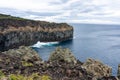 Waves crashing against dramatic cliffs on Terceira Island, Azores.