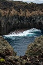 Waves crashing against dramatic cliffs on Terceira Island, Azores.