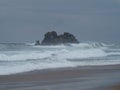Waves crashing against rock formation island pacific ocean coast sea shore Opoutere beach Waikato Coromandel New Zealand Royalty Free Stock Photo