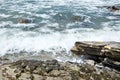 Waves crashing against a stones with foam and splashes. Ocean Rocky beach Royalty Free Stock Photo