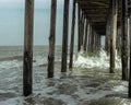 Ocean Waves Crashing Against Wooden Pier Posts