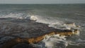 Waves crashing on the cliffy coastline in Portland, England,