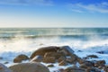 Waves crashing onto a rocky shore. A seascape view of the ocean with blue sky copy space in Camps Bay, Cape Town, South Royalty Free Stock Photo