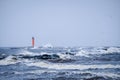 Waves crashing over a lighthouse, lighthouse in the sea in stormy day. Selective focus Royalty Free Stock Photo