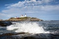 Waves Crashing on Rocks by Lighthouse in Maine