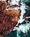 waves crashing on rocks near the shore with small white caps