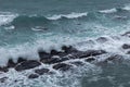 Waves crashing rocks at an overcast day Royalty Free Stock Photo