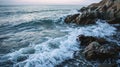 Waves crashing on rocky shoreline at dusk