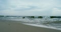 Waves crashing sand beach on grey cloudy weather. Aerial view ocean storming. Royalty Free Stock Photo