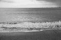 Waves crashing on a sandy beach on an overcast day