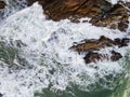 Waves crashing on seashore rocks,Top view sea surface waves background Royalty Free Stock Photo