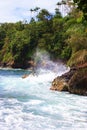 Waves crashing into the volcanic rocky shoreline at Onomea Bay in Papaikou, Hawaii Royalty Free Stock Photo