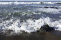 Waves crushing on a rocky beach making sea foam on Moonstone Beach