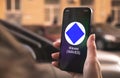 Waves cryptocurrency symbol, logo. Business and financial concept. Hand with smartphone, screen with crypto icon close