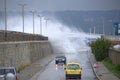 Waves flooding breakwater and cars