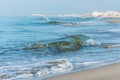 Waves with foam on the sea green color, long sandy beach. Royalty Free Stock Photo