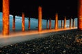 Waves foam under the Bridge, iron columns at the Seashore. Photo of waves on a long Exposure. Evening photo of the sea Royalty Free Stock Photo