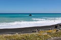 Waves and foam wash up on to the deserted beach at Cape Palliser, North Island, New Zealand