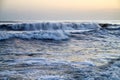 Waves with foam in a water of sea in the evening during sunset Royalty Free Stock Photo