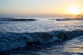 Waves with foam in a water of sea in the evening during sunset Royalty Free Stock Photo
