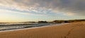 The waves and golden sand of a deserted beach