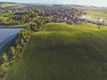 Waves on green field with small city