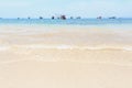 The waves had a clean white bubble lapping the sandy beach, With the backdrop of a group of fishing boats. Royalty Free Stock Photo