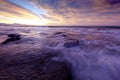 The waves at high tide overflow the rocky beach