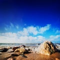 Waves hiting rocks on the sunny beach