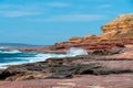 Waves hitting rock coast with different colors from red to yellow in the Kalbarri National Park Australia Royalty Free Stock Photo