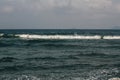 The waves near the shore foam, wave crests