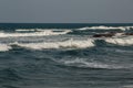 The waves near the shore foam, wave crests