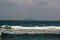 The waves near the shore foam, wave crests