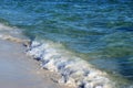 Waves from the ocean seethe and foam on the shore Royalty Free Stock Photo