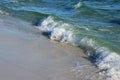 Waves from the ocean seethe and foam on the shore Royalty Free Stock Photo