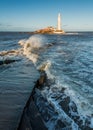 Waves over caueway at St Marys Lighthouse. Royalty Free Stock Photo