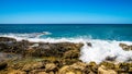 Waves of the Pacific Ocean crashing on the rocks on the shoreline of Ko Olina