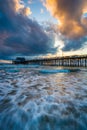 Waves in the Pacific Ocean and the Newport Pier at sunset Royalty Free Stock Photo