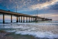 Waves in the Pacific Ocean and the pier at sunset Royalty Free Stock Photo