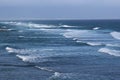 Waves of the Pacific Ocean rolling in while surfers paddle out at Hookipa Beach in Paia, Maui Royalty Free Stock Photo