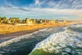 Waves in the Pacific Ocean and view of the beach from the fishing pier, in Imperial Beach, California. Royalty Free Stock Photo