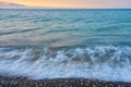 Waves on a pebble beach on a sunset. Royalty Free Stock Photo