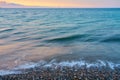 Waves on a pebble beach on a sunset. Royalty Free Stock Photo