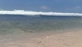 The waves, ripples and sea foam move onto the sand on the beach