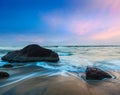Waves and rocks on beach on sunset Royalty Free Stock Photo