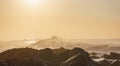 waves and rocks in early morning sun with glare and mist Royalty Free Stock Photo
